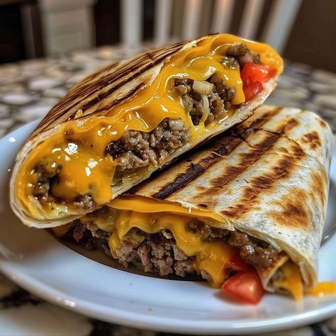 The Grilled Cheeseburger Wrap combines the classic flavors of a cheeseburger with the convenience of a wrap. It's a perfect fusion of two beloved dishes, offering a delightful twist on traditional fast food. This dish is not only easy to make but also customizable, allowing you to add your favorite toppings and sauces to suit...Read More Cheese Burger Wraps Ground Beef, Hamburger Wrap Recipes, Grilled Cheese Burger Wraps, Hamburger Sandwich Ideas, Wrap Burger Recipes, Grilled Cheeseburger Wraps, Burger In Tortilla Wrap, Bacon Cheeseburger Wraps, Cheeseburger Wraps Ground Beef