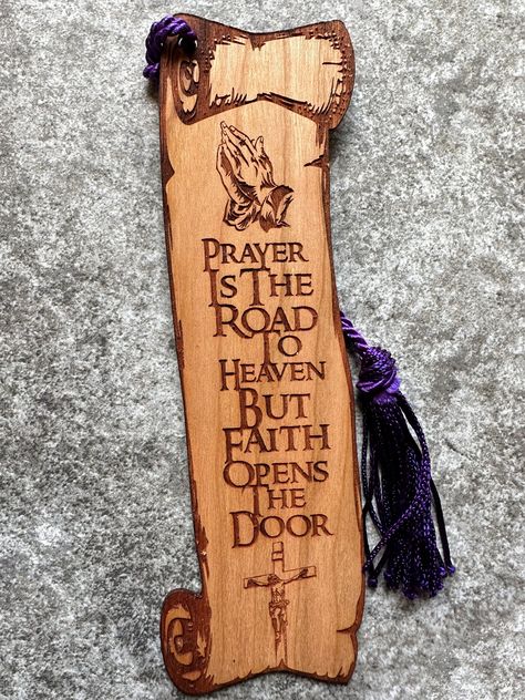 "Beautiful Christian bookmark made from a solid piece of cherry wood. The bookmark features an engraving of Jesus on the cross and a pair of hands praying, along with the phrase \"Prayer Is the Road to Heaven but Faith Opens the Door\" on a scroll shaped bookmark. Laser engraved to give it a beautiful 2D feel to it.  The bookmark can additionally be personalized on the back with either a name or message for a small additional cost. It measures approximately 6\"T x 2\"W and is 1/16\" thick (about Wood Burning Cross Designs, Christian Wood Burning Ideas, Hands Praying, Wood Crosses Diy, Diy Laser Engraver, Cross Bookmark, Wooden Bookmarks, Jesus Wall Art, Bible Bookmark