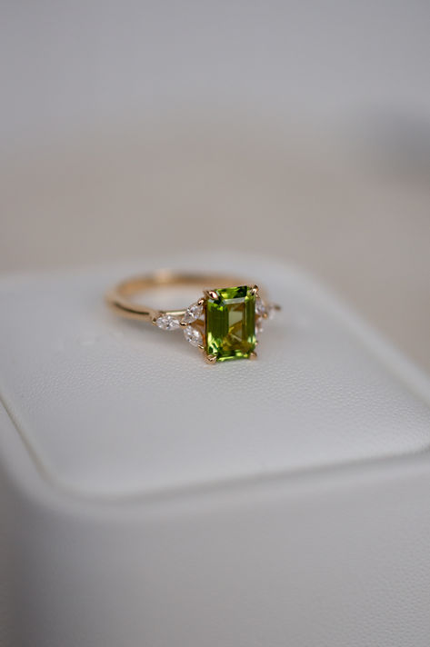 A gorgeous green emerald cut engagement ring, with marquise accent stones creating a floral / natura inspired silhouette. Green Emerald Cut Ring With Accent Stones, Diamond And Emerald Ring, Unique Green Emerald Cut Rings, Nature Inspired Emerald Engagement Ring, Emerald Engagement Ring Leaf, 70s Engagement Ring, Light Green Engagement Ring, Emerald Green Engagement Ring, Emerald Fairy Engagement Ring