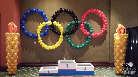 Olympic rings made from  balloons with balloon torches to match | Balloons by Tommy | #balloonsbytommy Olympic Vbs, Olympic Party Decorations, Summer Olympics Party, Vbs Olympics, Swim Banquet, Family Olympics, Office Olympics, Olympics Decorations, Olympic Theme Party