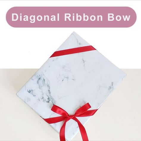 Tying diagonal ribbon bow around gift wrapping box Diagonal Ribbon On Gift, Ribbon On Presents, Tie Bows With Ribbon, Christmas Present Ribbon, Bows For Presents, Diy Gift Bow, Wrap A Gift, Wrapping Ribbon, Present Box