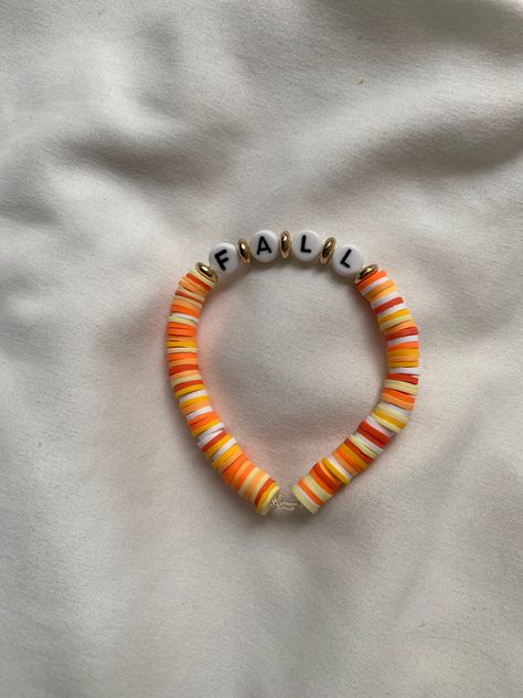 A fall themed bracelet. Cool Bead Bracelet Patterns, Braclet Ideas Clay Bead Fall, Thanks Giving Bracelets, Preppy Fall Bracelet Ideas, Preppy Halloween Bracelet, Clay Bead Bracelet Ideas Thanksgiving, Fall Bracelets String, Halloween Diy Bracelets, Fall Themed Bracelets