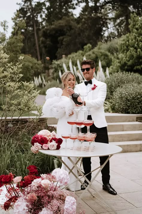 Red and pink wedding theme at Middleton Lodge. The bride wears a Chosen by Kyha dress with puff sleeves adorned with pearls and Chanel shoes. Pink And Red Wedding Groomsmen, Light Pink And Red Wedding, Red Pink Wedding Theme, Red Pink And White Wedding Theme, Pink And Red Bridesmaid Dresses, Cherry Red Wedding, Valentine’s Day Wedding, Pink And Red Wedding Theme, Red Pink Wedding