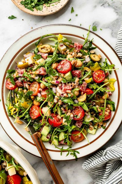 This Hearty Italian Farro Salad is like antipasto pasta salad, made with healthy whole grains! Toss hearty farro with soppressata, asiago cheese, olives, pepperoncini, arugula, & a zingy Italian dressing for an easy, satisfying grain salad. A beautiful light summer dinner & the perfect make-ahead side for picnics or BBQs! (Easily vegetarian & dairy-free) #italianfarrosalad #farrorecipes #farrosalad #grainsalad #grainsaladrecipes #healthygrainsalads #saladrecipes #saladideas #saladsforparties Antipasto Pasta Salad, Antipasto Pasta, Grain Salad Recipes, Light Summer Dinners, Farro Recipes, Antipasto Pasta Salads, Satisfying Salads, Farro Salad, Grain Salad