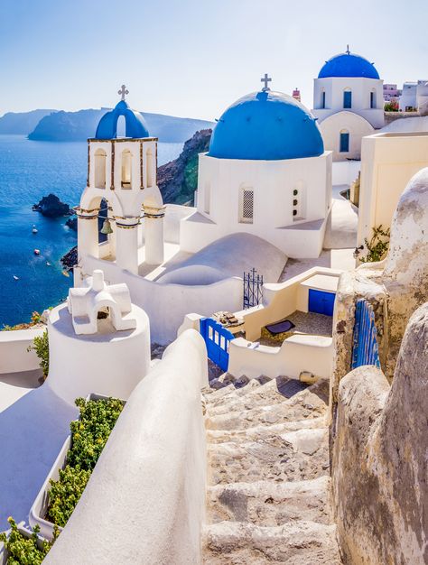 Mediterranean sunshine beams down on a honeycomb of whitewashed homes, hotels, cafes, and long stairways that wind down to the deep blue sea.  Roughly 3,500 years ago one of the Earth's largest volcanic events took a bite out of the island now known as Santorini (or officially: Thira). Built on the northern edge of the island's caldera, Oia is wedged into rock crevices and perched atop rugged cliffs overlooking the southern Aegean Sea. Grecia Santorini, Kusadasi, Oia Santorini, Santorini Island, Dream Travel Destinations, Beautiful Villages, Santorini Greece, Beautiful Places To Travel, Greece Travel