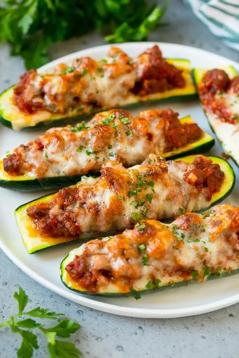 A plate of stuffed zucchini boats filled with a savory meat sauce and topped with mozzarella cheese. Zucchini Stuffed, Zucchini Boat Recipes, Stuffed Zucchini Boats, Sommer Mad, Sausage Stuffed Zucchini, Stuffed Zucchini, Zucchini Pizzas, Zucchini Boats, Classic Italian Dishes