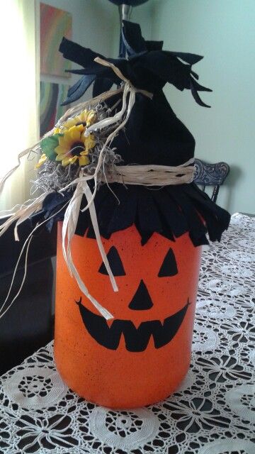 This is a large glass pickle jar that I painted a pumpkin face on, added a felt hat and some sunflowers. Gallon Jar Crafts, Fall Jar Crafts, Large Pickle Jar Ideas, Pickle Jar Crafts Diy, Pickle Jar Crafts, Crafts With Glass Jars, Halloween Jars, Mason Jar Centerpiece, Halloween Mason Jars