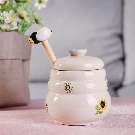 Brand Kosmeey Capacity 10 Ounces Product Dimensions 4.5"L x 4"W x 4"H Honey Jar with dipper is made of ceramic material without lead and cadmium. It is so easy to clean, you may wash it by hand; this is good for your health. Also, no more crystallizing, your honey is always ready to go! 𝐀 𝐒𝐌𝐀𝐑𝐓 𝐆𝐈𝐅𝐓 𝐄𝐕𝐄𝐑𝐘𝐎𝐍𝐄 𝐖𝐈𝐋𝐋 𝐋𝐎𝐕𝐄 – Make someone’s life a little sweeter. Offer this lovely honey pot to members of your family, friends, or coworkers as a thoughtful and useful present! Bee Pot, Urban House, Honey Bee Decor, Honey Dipper, Smart Gift, Bee Decor, Honey Jar, Victoria Bc, Honey Pot