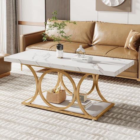 [Sophisticated Modern Coffee Table]: With a cultured white marble veneer top and gold geometric metal legs, adding a touch of modern luxury to the entire coffee table, create a cozy, warm feel in your living space.
[2-Tier Center Table]: Spacious tabletop and bottom shelf perfect for keeping your living room supplies organized and your daily essentials close at hand. The minimalist coffee table help to create a clean and clutter-free space that’s perfect for relaxing. Marble Veneer, Faux Marble Coffee Table, Modern Wood Coffee Table, Rectangle Coffee Table, Minimalist Coffee, Gold Dining, Room Supplies, Minimalist Coffee Table, Simple Coffee Table