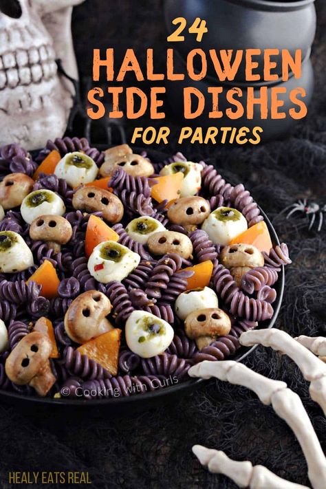 A plate of Halloween-themed pasta containing rotini, mozzarella balls with pesto, and orange bell pepper pieces, garnished to look like skulls; background features a skull and skeleton hand. Text reads "24 Spooky Halloween Side Dishes for Parties." Spider Bread Bowls For Halloween, Easy Halloween Main Dishes, Healthy Halloween Side Dishes, Halloween Cookout Food, Halloween Party Sliders, Halloween Food Ideas Veggies, Easy Food For Halloween Party, Spooky Sides For Halloween, Halloween Themed Casseroles