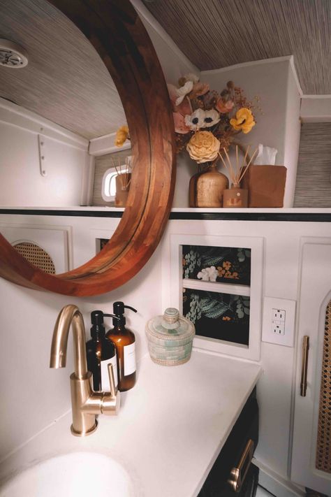 Bathroom with black cabinets and brass hardware, mahogany mirror and flowers Yacht Style Interior Home, Boat Bathroom Remodel, Sailboat Renovation Interior Design, Boat Renovation Interior Design, Yacht Renovation, Sailboat Interior Remodel, Boat Bathroom Ideas, Sailboat Renovation, Boat Interior Remodel