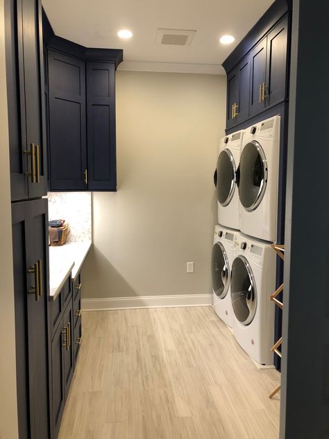 Blue cabinets, gold hardware, double washer dryer, porcelain wood grain tile planks, silestone counter Double Stack Washer And Dryer, Laundry Room Design Double Washer Dryer, Double Stack Washer And Dryer Room Ideas, Laundry Room With Double Washer Dryer, Dual Washer And Dryer Laundry Room, Double Stackable Washer And Dryer, Double Washing Machine Laundry Room, Laundry Room 2 Washers 2 Dryers, Laundry Room Double Washer Dryer