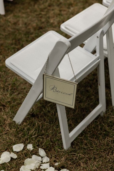 Reserved sign wedding, tent wedding, rainy wedding day, garden wedding, white wedding chairs, petals down aisle, white roses wedding ceremony, all white wedding, blue reserved chair,  Oyster Bay Yacht Club, Fernandina Beach, Amelia Island, Jax, Jacksonville, Florida, Fl, Wedding Venue, Wedding Wire, Weddings, Wedding Coordinator, Wedding Ideas, Wedding Inspo, Wedding Inspiration, wedding flowers, white wedding flowers, we are the bowsers, photographer, photography, greenery, bridal bouquet Petals Down Aisle, White Wedding Chairs, Reserved Sign Wedding, Greenery Bridal Bouquet, Wedding Flowers White, Rainy Wedding Day, White Roses Wedding, Wedding Chair Decorations, All White Wedding