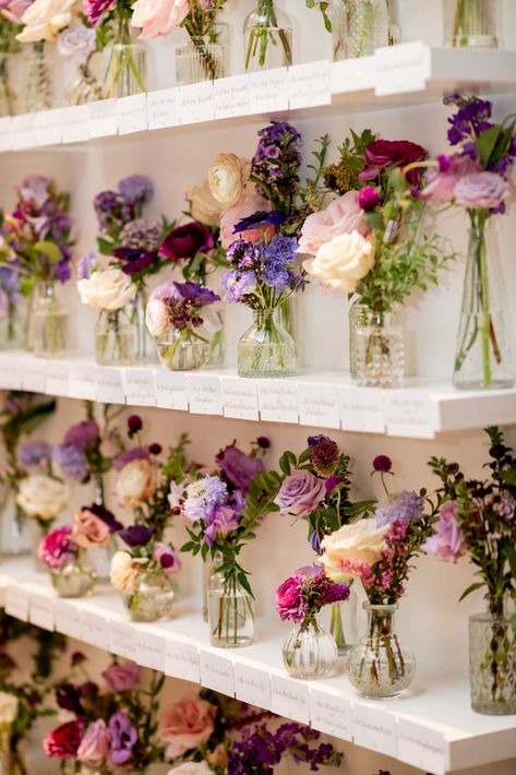 Elegant bud vases decorate the escort display of this fall wedding reception. Purple wedding flowers in hues of lavender, mauve, blush, and plum. Fall wildflowers for fall wedding reception. Design by Rosemary & Finch Floral Design in Nashville, TN. Purple Table Centerpieces Wedding, Lavender Floral Arrangements Wedding, Ideas For Wedding Table Decorations, Lilac Wedding Flowers Table, Wedding Table Lavender, Lavender Bud Vases, Purple And Champagne Wedding Colors, Purple Whimsical Wedding, Plum Flowers Wedding