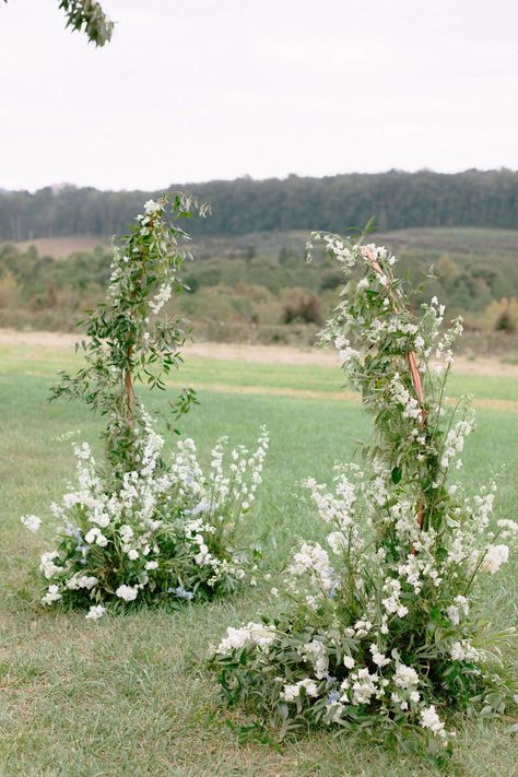 This classic ceremony backdrop floral arrangement was designed with your classic ivory palette but with hints of blue giving it whimsical feel! Visit our blog to see more pictures. Greenery Ceremony Backdrop, Whimsical Ceremony Arch, Flower Arch For Wedding Ceremony, Ceremony Backdrop Flowers, Whimsical Wedding Arbor, Blue And White Wedding Arbor, Ceremony Flowers Altar Outdoor, Wedding Florals Arch, Simple Wedding Arch Ideas Outdoor Ceremony