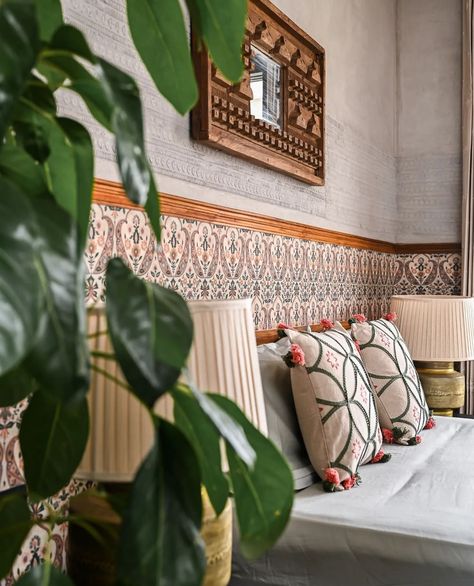 A beautiful guest bedroom space featuring a bespoke antique mirror, Sabyasachi wallpaper accents, brass lamps, and a stunning black slate floor • designed by @studio.Ruh Featuring Sabyasachi ‘Jaipur Valencia’ wallpaper in the color ‘Mogra’ in 2 ways: 1️⃣ Accent Wall Behind Bed: Use the wallpaper on the lower half of the wall for a bold look, paired with a crisp neutral on top for balance. 2️⃣ Art Accent Panel by Desk: Install one roll of wallpaper from ceiling to floor next to the desk f... Indian Themed Bedroom, Sabyasachi Wallpaper, Accent Wall Behind Bed, Wallpaper Accents, Airbnb Photos, Black Slate Floor, Styling Bedroom, Indian Bedroom Design, Wall Behind Bed