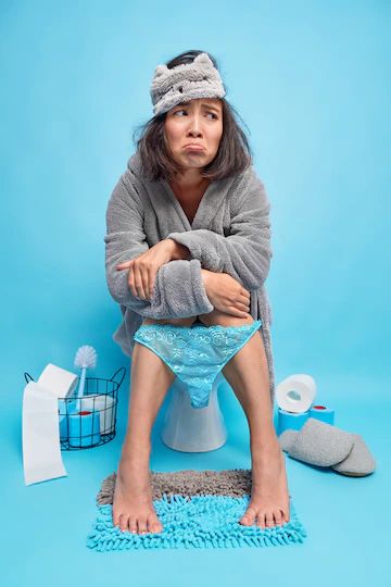 Free Photo | Displeased asian woman feels unhappy and sleepy after early awakening wears sleepmask bathrobe and lace pants pulled down on legs poses in restroom on toilet bowl blue wall suffers from diarrhea Legs Poses, Smiling Person, Concept Photography, Blue Girl, Goth Steampunk, Test Shoot, Lace Pants, Person Sitting, Blue Bathroom