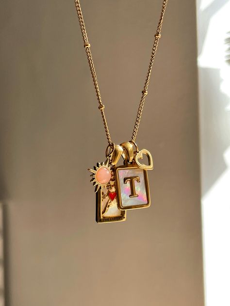 Gold and pink Taylor swift lovers inspired necklace. Mother of Pearl T initial charm. Small heart charm. Pink sun charm. The lovers tarot card charm. Taylor Swift Inspired Necklace, Taylor Swift Charms, Taylor Swift Locket Necklace, Taylor Swift Folklore Necklace, Taylor Swift Initial Necklace, Taylor Swift Fearless Necklace, Taylor Swift Jewelry Necklaces, Taylor Swift Necklace, Taylor Swift Archer Necklace