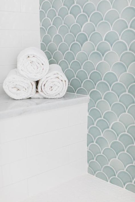 A white tiled bench with a marble top is fitted against white staggered backsplash tiles and adjacent to a seafoam green tiled accent wall. Coastal Bathroom Shower Tile, Fish Scale Backsplash Bathroom, Glass Tile Accent Wall Bathroom, Shower Niche Tile Ideas Accent Wall, Coastal Floor Tile, Scallop Backsplash Bathroom, Accent Wall Shower Tile, Shower Only Bathroom Ideas, Sea Foam Green Bathroom