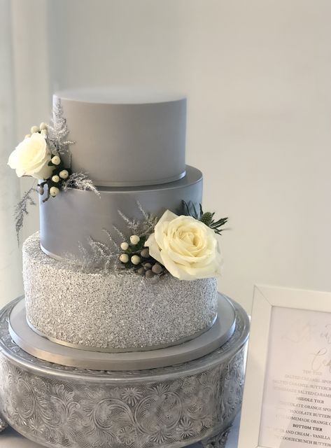 Silver grey wedding cake with fresh flowers.  Perfect for your Christmas wedding, sparkly glitter tier and a silver satin tier, finished off with beautiful fresh Christmas flowers. Grey Wedding Cake Ideas, Grey Cake Ideas, Grey Wedding Cakes, Silver Cake Ideas, Grey Wedding Decorations, Wedding Cake Silver, Grey Wedding Cake, Prom Cake, Silver Wedding Anniversary Cake