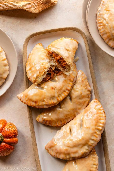 These baked pumpkin hand pies start with a homemade pie dough, are filled with a simple pumpkin pie filling, and finished with a sweet maple glaze. Easily portable personal pumpkin pies with extra flaky crust... what could be better? Recipe on sallysbakingaddiction.com Pumpkin Hand Pies Recipes, Hand Pie Dough Recipe, Hand Pies Dough Recipes, Simple Pumpkin Pie, Homemade Pie Dough, Pumpkin Slab Pie, Pumpkin Hand Pies, Vegan Winter Recipes, Pie Dough Recipe