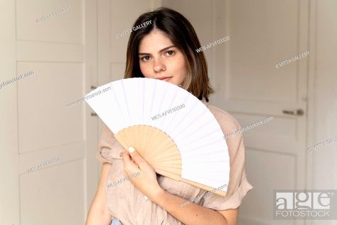 Portrait of brunette young woman holding fan, Stock Photo, Picture And Royalty Free Image. Pic. WES-AFVF03320 | agefotostock Holding Fan Pose Drawing, Holding A Fan Pose, Fan Holding Reference, Holding Fan Pose Reference, Hand Holding Fan Reference, Fan Pose Reference, Holding Fan Reference, Fan Drawing, Golden Thread