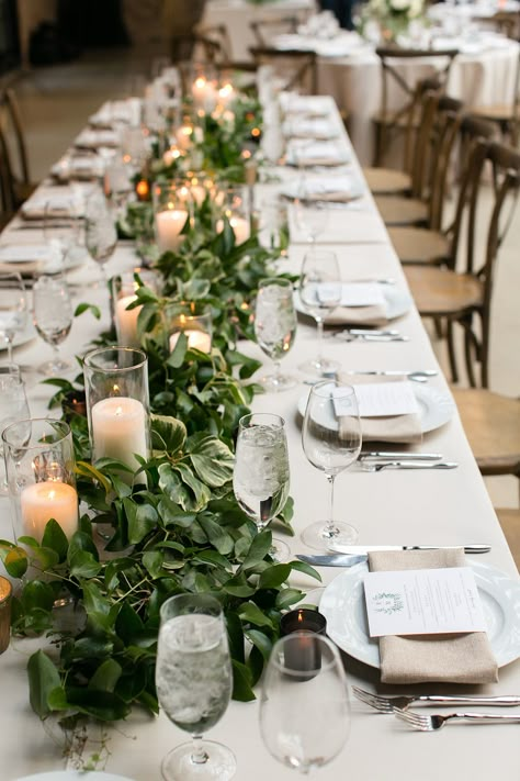 Emily & Matthew's Romantic Industrial Wedding - Chicago Style Weddings Diy Greenery Table Runner Wedding, Wedding Table With White Tablecloth, Greenery And Candle Table Runner, Greenery Runner With Candles, Candle Table Runner Wedding, Floral Table Runner With Candles, Wedding Reception Table Runners, Greenery Runner Wedding, Industrial Wedding Table Decor