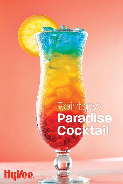 Sip on this layered summer cocktail while daydreaming of your next vacation. This simple rainbow drink recipe is made by slowly pouring in a combination of coconut rum, grenadine, and blue curacao. Cheers to patio happy hours everywhere! Paradise Cocktail Recipe, Cocktail Recipes Blue Curacao, Pride Drink Recipes, Rainbow Mocktails Non Alcoholic, Rainbow Drinks Alcohol, Rainbow Cocktail Recipe, Rainbow Paradise Cocktail, Pride Cocktail Recipes, Drinks With Blue Curacao