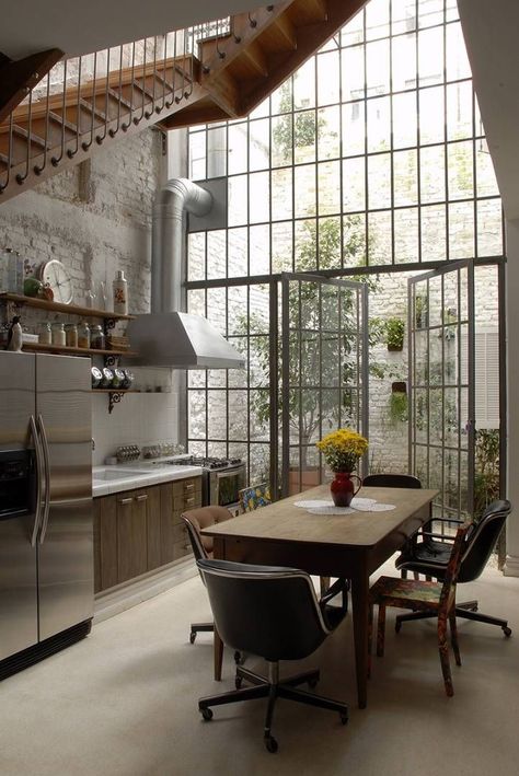 factory-metal-windows-garden-estudio-vitorpenha-gardenista. Two-story factory windows and French doors bring sunlight into a kitchen by Brazil-based Estudio Vitor Penha. WOW!!! Loft Kitchen, Bohol, Design Del Prodotto, Open Kitchen, Architectural Digest, Design Case, Modern Industrial, Home Fashion, 인테리어 디자인