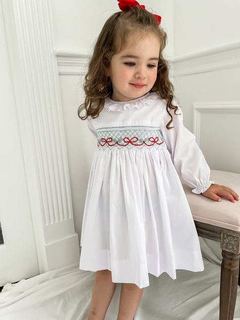 PRE-ORDER - SHIPPING IN NOVEMBER. ESTIMATE DELIVERY DATE PLEASE READ: If you are ordering in stock items along with PRE-ORDER items, they will ship on the PRE-ORDER listing date. If you need the in stock item earlier, please place a separate order.  The Blakely Smocked Gingham Bishop Dress is a holiday staple for your little girl! A hand-embroidered detailed bow and holly design add a cheerful touch to this dress! Clothing Care Instructions: Machine wash gentle. Do not bleach. Tumble dry delicat Christmas Smocked Dresses, Baby Christmas Dress, Santa Sessions, Red Bow Christmas, Chunky Crochet Baby Blanket, Smocked Christmas Dresses, Smocking Designs, Smocked Bishop Dress, Toddler Christmas Dress