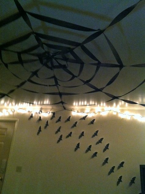 Halloween decor: -"Spiderweb" (black party streamers)  -Flying paper bats Halloween Party Hanging Decor, Spiderweb Decor, Goth Ceiling Decor, Streamer Spider Web, Streamer Decorations Halloween, Spider Ceiling Decoration, Goth Halloween Decor, Easy Halloween Party Decorations, Black Streamers Halloween