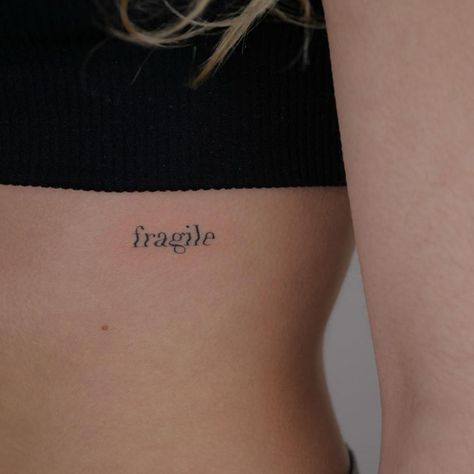 fragile tiny tattoo on rib feminine Fragile Word Tattoo, Most Feminine Tattoo Placement, Dainty Rib Cage Tattoos, Fragile Tattoo Words, Placements For Small Tattoos, Tiny Rib Tattoo, Tattoo Placements For Women, Dainty Rib Tattoos For Women, Ribs Tattoo For Women