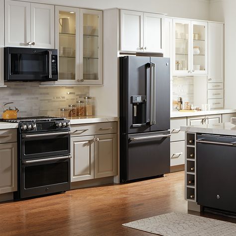 These on-trend appliance finishes help express your style, shake up the look of your kitchen and make an update feel fresh. Stove Next To Refrigerator Kitchen, Kitchen Colors Schemes With Black Appliances, Black Frigerator In Kitchen, Black Fridge Kitchen Interior Design, Small Kitchen Ideas Black Appliances, Stainless Black Kitchen Appliances, Black Appliances With White Cabinets, Kitchenaid Black Stainless Appliances, Black Slate Appliances Kitchen