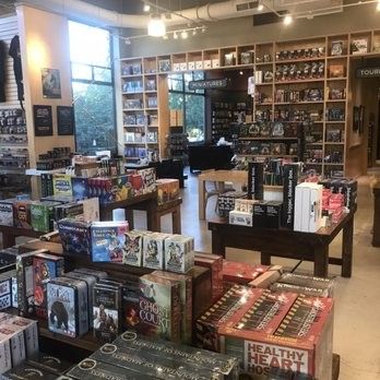 Tabletop Game Store, Game Store Aesthetic, Board Game Cafe Interior, Boardgame Cafe Interior, Gaming Retail Store Design, Store Board Games, Cat Gaming, Comic Book Crafts, Script Analysis