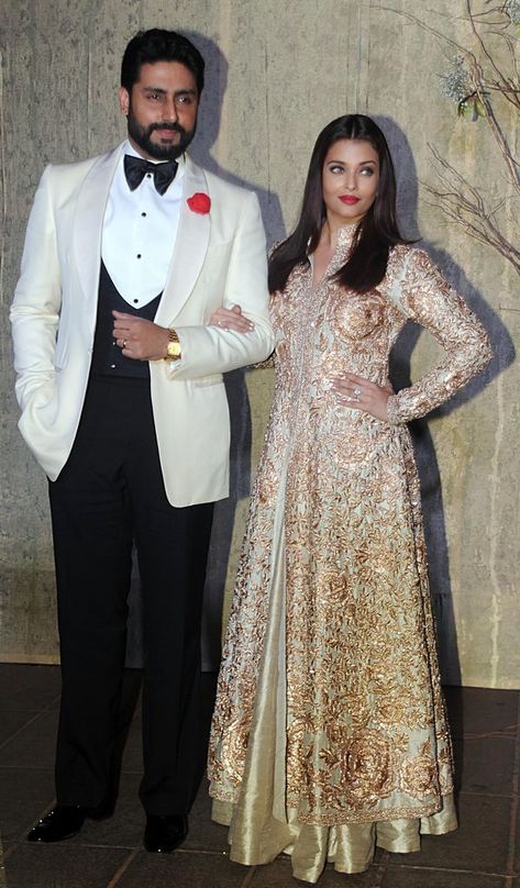 Posing with her husband Abhishek Bachchan wearing a gold embroidered Indian outfit. Image Sour... Aishwarya Rai Cannes, Latest Bridal Dresses, Wedding Couple Poses Photography, Wedding Couple Poses, Aishwarya Rai, Indian Outfit, Bollywood Stars, Indian Designer Outfits, Gentleman Style