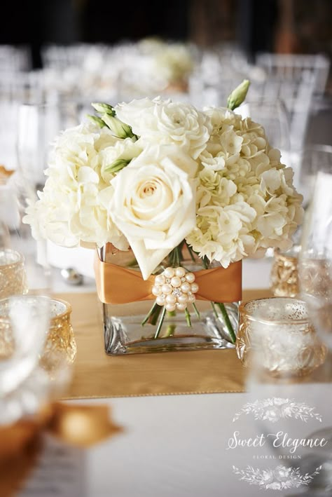 Classic, elegant cream rose and white hydrangea centerpiece with gold ribbon and pearl accent. Pearl Accent Wedding Decor, Hydrangea Roses Centerpiece, Ivory Flower Centerpieces, Pearl And Flower Centerpieces, Wedding Centerpieces Gold And White, Cream And Gold Centerpieces, Pearls In Flower Arrangements, White And Gold Flower Arrangements Centerpiece Ideas, 50th Anniversary Flower Centerpieces