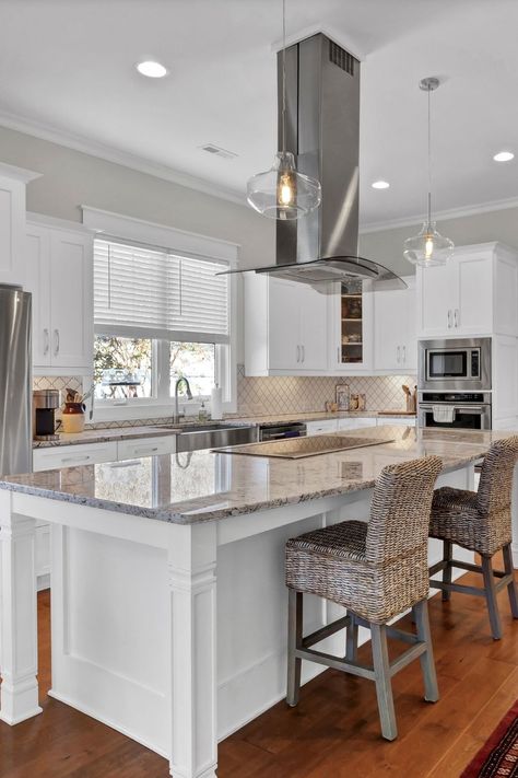 The island in this gourmet kitchen is very functional with a cooktop and vent hood. Kitchen Island Ideas With Cooktop, Kitchen Island Stove Hood, Stove On The Island, Kitchen With Island Stovetop, Kitchen With Stove On Island, Island Cooktop With Hood, Stovetop In Island Kitchen, Stovetop On Island, Island With Range Hood