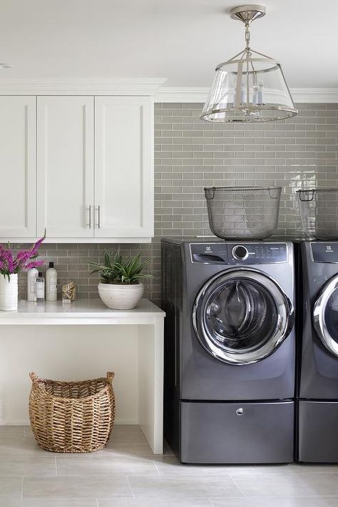 Laundry room with washer and dryer pedestal risers display metal baskets for a vintage touch. Laundry Room Pedestal, Washer And Dryer Pedestal, Room Floor Tiles, Transitional Laundry Room, Laundry Room Storage Shelves, Room Storage Diy, Basement Laundry Room, Laundry Room Flooring, Dream Laundry Room