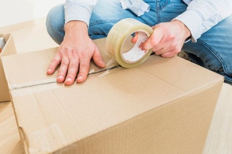 Young man sealing cardboard box with tap... | Premium Photo #Freepik #photo #people #house #circle #hand Office Tape, Corrugated Carton, Acrylic Glue, Moving Long Distance, Packaging Tape, Tape Dispenser, Packers And Movers, Packing Tape, Packaging Supplies