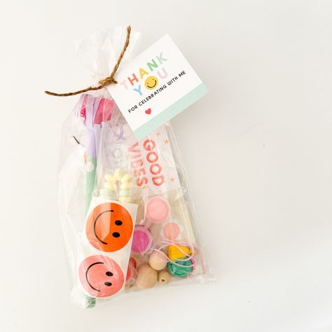 "Adorable DIY happy face party favor bags for kids! Good vibes only with these fun goodie bags that include diy keychain kits that are fun to craft!  Each favor bag includes:  + DIY happy face keychain kit  + party blower + 2 smiley face stickers + candy bracelet + \"thank you for celebrating with me\" tag + individually wrapped in a cellophane bag with twine Suggested for ages 4+  Please select the color of your charm and the quantity needed in the drop down menu. FREE shipping when you purchase 4+  At Cottonwood Home, we understand that time with your kids is valuable. Our party kits and children's décor help save time so you can celebrate life's special moments!  Visit our main website for more fun! > cottonwoodhome.com" Kids Gift Bags Birthday Party Favors, Birthday Goody Bags, Cute Party Favors For Kids, Party Goodie Bag Ideas, Birthday Goodie Bags Ideas, Favor Bags For Kids Birthday Ideas, Party Favor Bags For Kids, Goody Bags For Kids Party, Goodies Bag Ideas For Kids Birthday