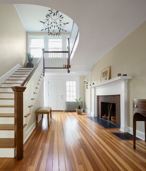 Click the link to see the rest of this home! Natural woods complement the original fireplace and grand staircase in this Colonial Home. #entryway #foyer #colonial #staircase Foyer Fireplace Entryway, Fireplace In Foyer Entryway, Colonial Home Entryway, Fireplace Entryway Foyer, Double Staircase Foyer, Colonial Staircase, Colonial Fireplace, Fireplace Entryway, Original Fireplace