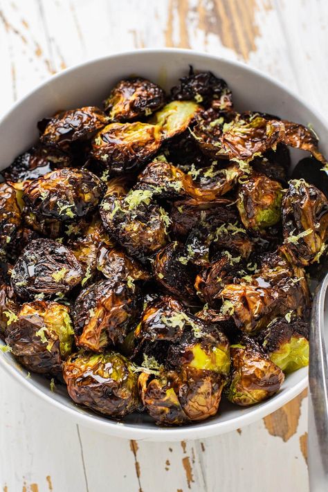 These crispy roasted restaurant-style brussels sprouts have quickly become our favorite way to prepare brussels sprouts. These brussels are halved and roasted cut side down on a hot baking sheet until they're golden brown and ultra tender. While you can certainly eat them as is, they're finished with a drizzle of balsamic glaze, honey, and freshly zested lemon. #brusselsprouts #roastedveggies Brussel Sprouts Baked, The Best Brussel Sprouts, Crispy Baked Brussel Sprouts Oven, Glazed Brussel Sprout Recipes, Best Roasted Brussels Sprouts, Whole Brussel Sprout Recipes, Crispy Roasted Brussels Sprouts, Crispy Brussels Sprouts Roasted, Roasted Brussels Sprouts With Balsamic