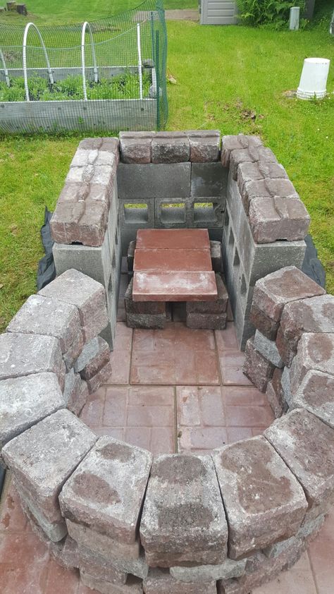 Keyhole fire pit with grilling area.   4 foot circle, outside diameter, with ~3 foot square raised grilling area.  Cinder blocks, pavers, and retaining wall bricks. Keyhole Fire Pit, Retaining Wall Bricks, Outdoor Fire Pit Seating, Grilling Area, Gazebo With Fire Pit, Outside Fire Pits, Fire Pit Cooking, Brick Fire Pit, Fire Pit Ideas