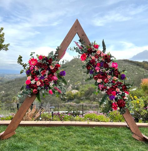 "Handmade in the USA Color Combo Floral selection is variable with each design. Make a Blissful statement with this stunning Jewel Tone wedding ceremony triangle archway flower package. Designed on a flexible base (allowing for a straight, curved for your circle arch or angled for a corner or hexagon arch display) with high quality faux floral and greenery. The primary floral design measures 5.5ft in total length by 32\" wide tip to tip. The Accent designs measure 4ft in length by 44\" wide tip Jewel Tone Wedding Ceremony, Fuchsia Wedding Flowers, Jewel Tone Wedding Theme, Jewel Tone Wedding Colors, Arch Display, Jewel Tone Wedding Flowers, Circle Arch, Fuchsia Wedding, Wedding Flower Packages