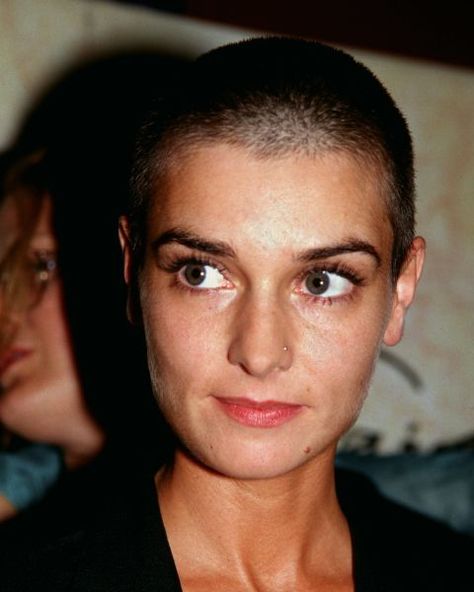 Since the '90s, singer Sinead O'Connor has held onto her trademark shaved head — though she almost grew it out until somebody mistook her for fellow singer Enya. "I don't feel like me unless I have my hair shaved," she said. "So even when I'm an old lady, I'm going to have it." Girls Shaved Head, Girls With Shaved Heads, Women With Short Hair, Shaved Head Women, Irish Singers, Shave Her Head, Shaved Heads, Shave My Head, Hair Mistakes