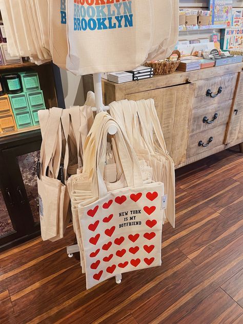 Tote Bag Display Ideas, Display Tote Bags, Bags Exhibition Display, How To Display Tote Bags At A Craft Fair, Tote Bag Display, Tote Bag Display Craft Fair, Shopping Tote Bag With Branding, Screen Print Tote Bag For Shopping, Gift Shop Interiors