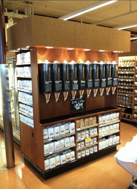 The Original Coffee Bean Hoppers come in a wide range of coffee blends. This is a particularly well-organized event. Everything is displayed equally, and the coffee-dispensing pipes are brightly colored. The appearance is important when displaying the merchandise. Customers will be drawn to the display because it appears to be well-organized, and it will be the first thing they see because it is in a prominent location. Coffee Bean Display, Coffee Store Design, Industrial Coffee Shop, Coffee Bean Shop, Coffee Display, Raw Coffee Beans, Different Coffee, Types Of Coffee Beans, Cafe Display