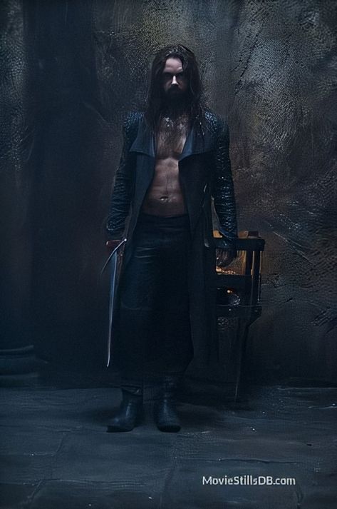 Young Michael Sheen in costume as Lucian. He’s wearing a leather outfit that includes black leather trousers and open jacket, with no shirt. He’s holding a sword. He has long dark hair and a short beard. He’s standing in a dark room and he looks menacing. Underworld Lycans, Underworld Michael, Lucian Underworld, Underworld Rise Of The Lycans, Underworld Movies, Rhona Mitra, Bill Nighy, Vampire Movies, First Blood