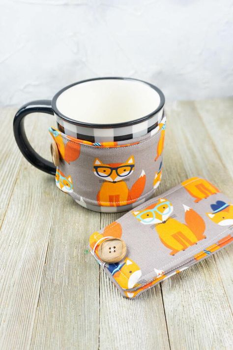 Tired of burning your hands on your hot coffee or hot tea then this Simple Sew Mug Warmer is the perfect sewing project for you. It helps keep that warm goodness hot while keeping your fingers and hands from getting burned. Plus you can customize these to match your style or even better make them for a friend that loves coffee or tea. Choose a cute fabric and start making your own mug warmer today. Plus you can use scraps from other projects to sew this mug warmer. Some people call these a mug w Diy Coffee Sleeve, Make Your Own Mug, Coffee Cozy Pattern, Mug Noel, Mug Cozy Pattern, Coffee Mug Cozy, Coffee Cups Diy, Cup Cozy Pattern, Coffee Cup Cozy