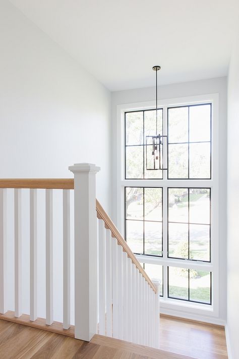 Floor-to-ceiling windows bring plenty of natural light to this stairway Wall paint color is Sherwin Williams Site White #stairway #windows #paintcolor Windows On Staircase Wall, Stair Case Windows, Stair Case Windows Design, Window Stairs Design, Stairway Window Ideas, Stairs Window Design, Stair Case Ideas, Window Stairs, Staircase Window